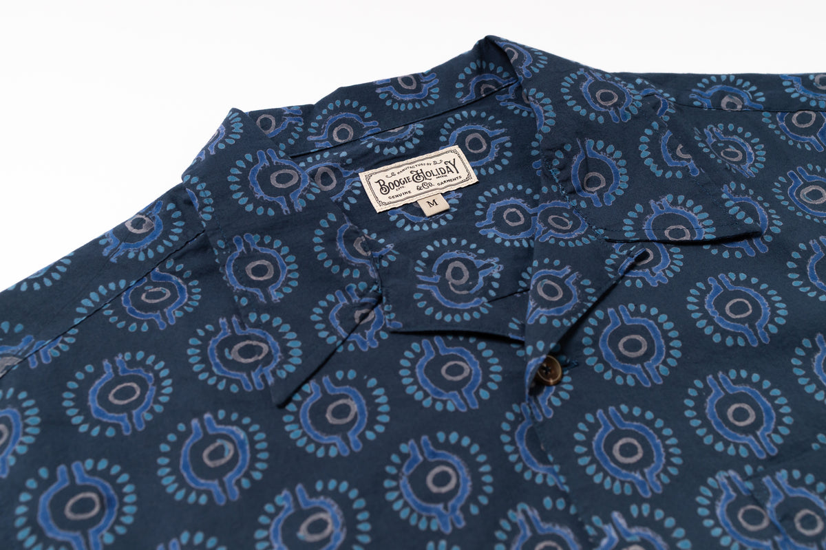 Blue patterned shirt with a brand label on a white background