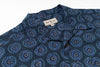 Blue patterned shirt with a brand label on a white background