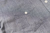 Close-up of a gray shirt with a pocket and button