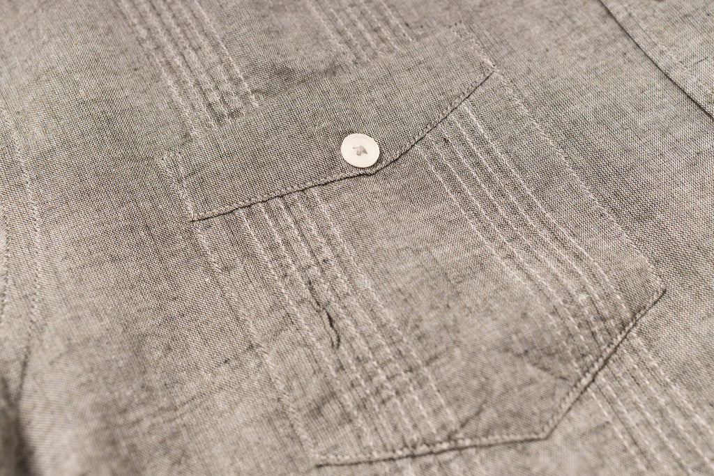 Close-up of a textured gray fabric with a button detail