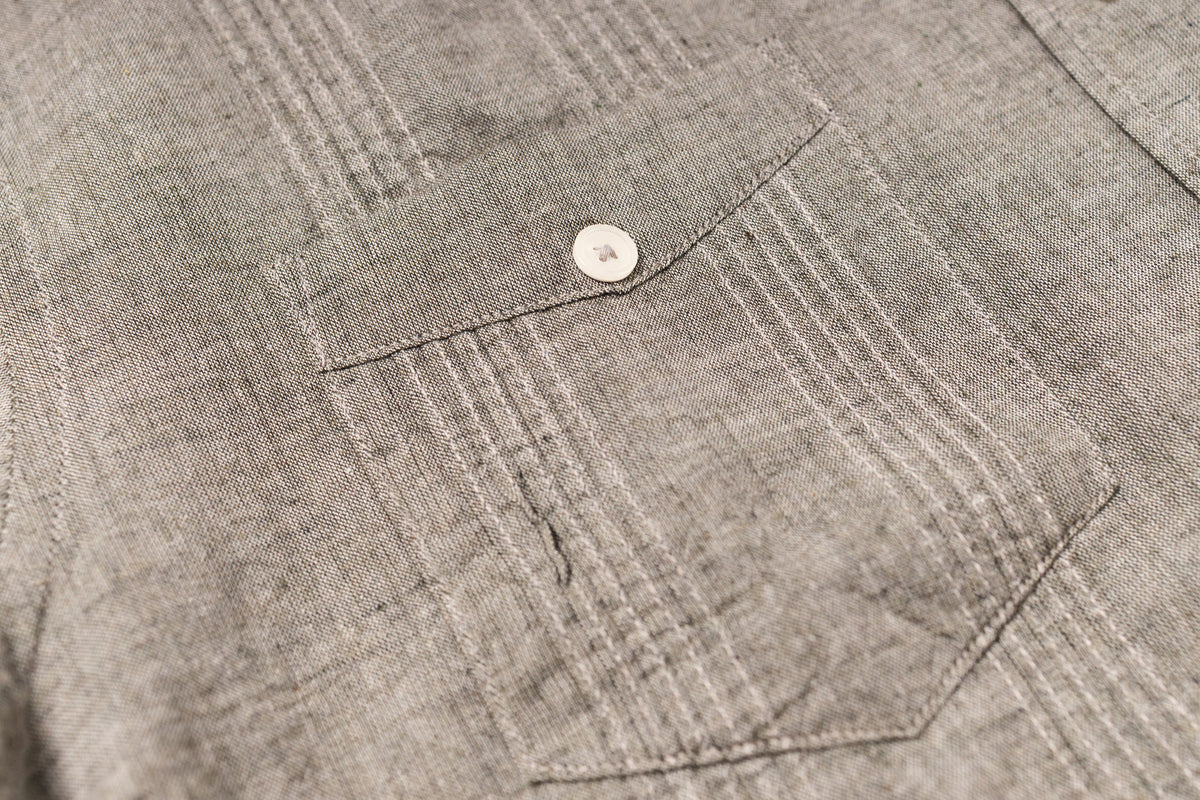 Close-up of a textured gray fabric with a button detail
