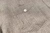 Close-up of a textured gray fabric with a button detail
