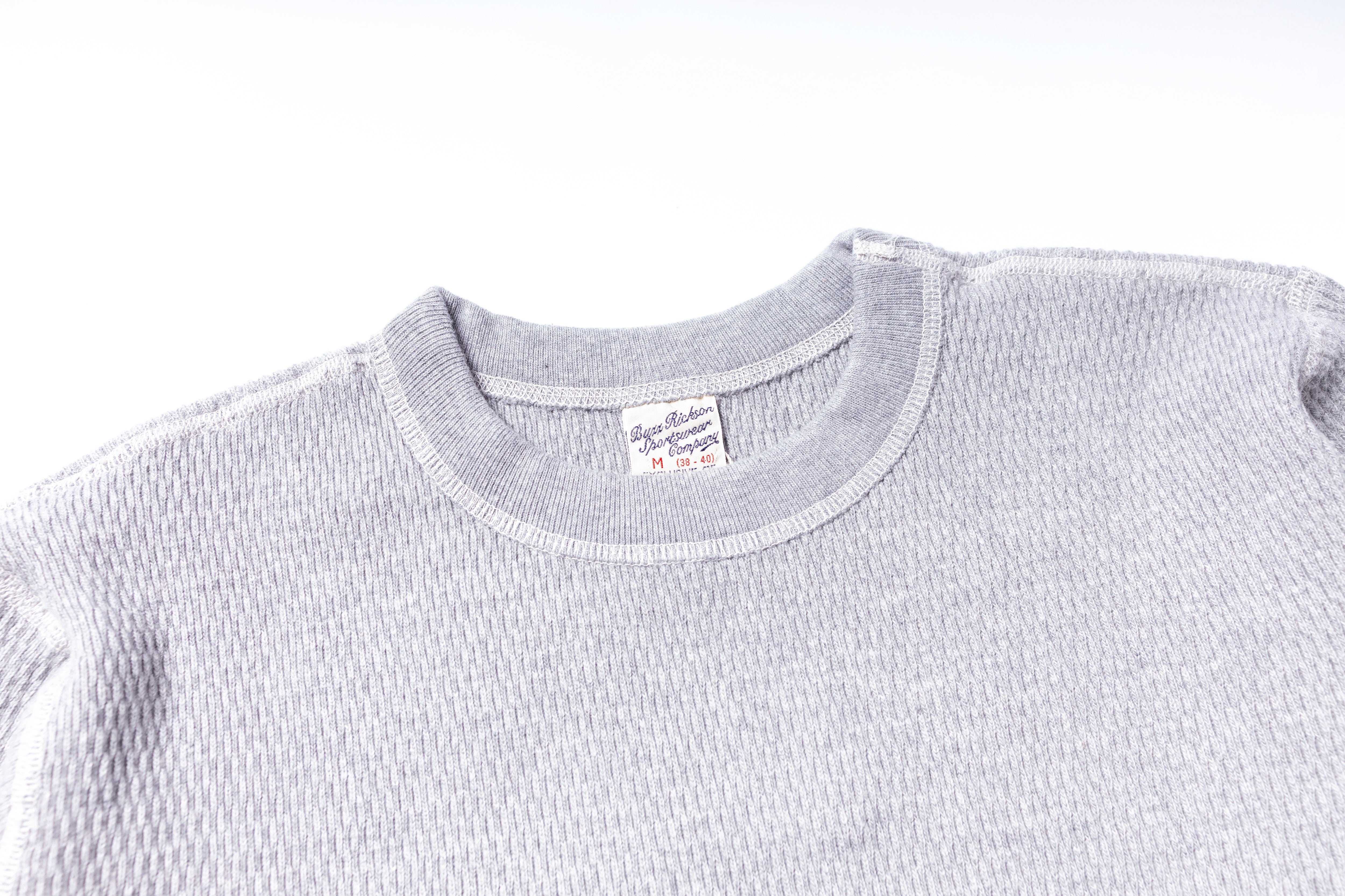 Gray textured sweater with a brand label on a white background
