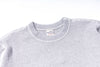 Gray textured sweater with a brand label on a white background