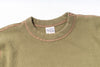 Close-up of a green sweater with a brand label on a white background
