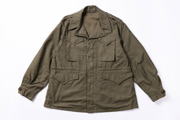 Green military-style jacket on a white background