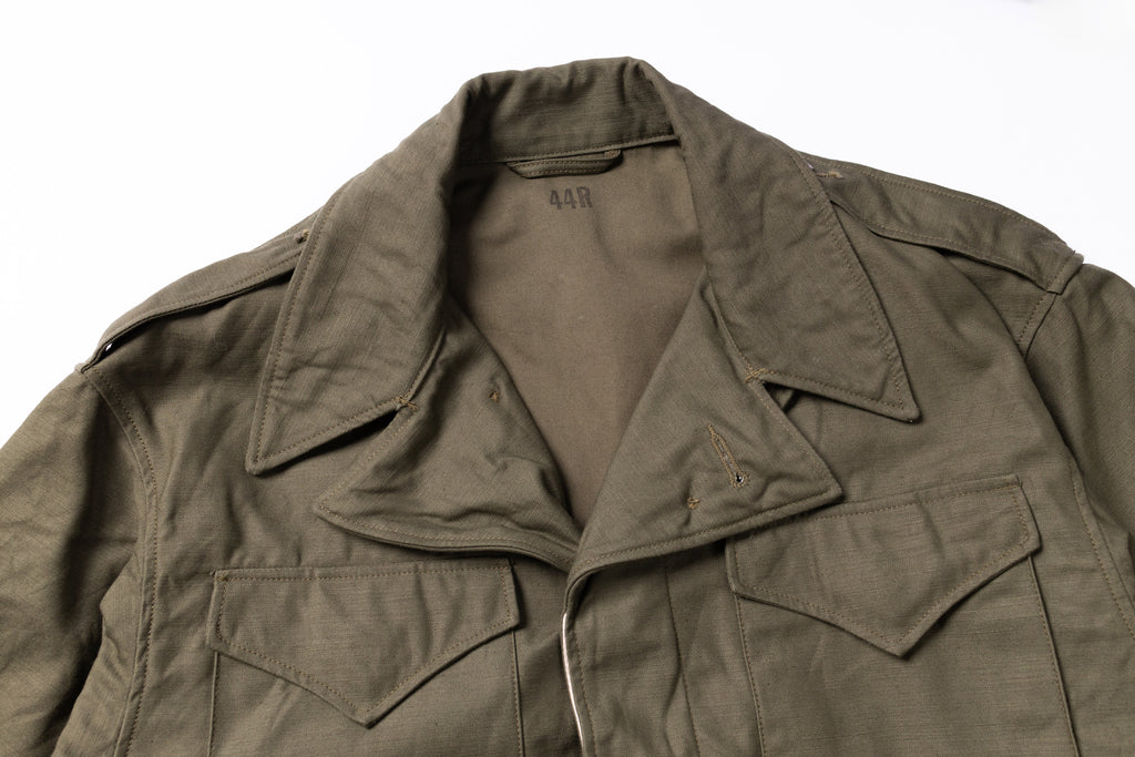 Green military-style jacket on a white background