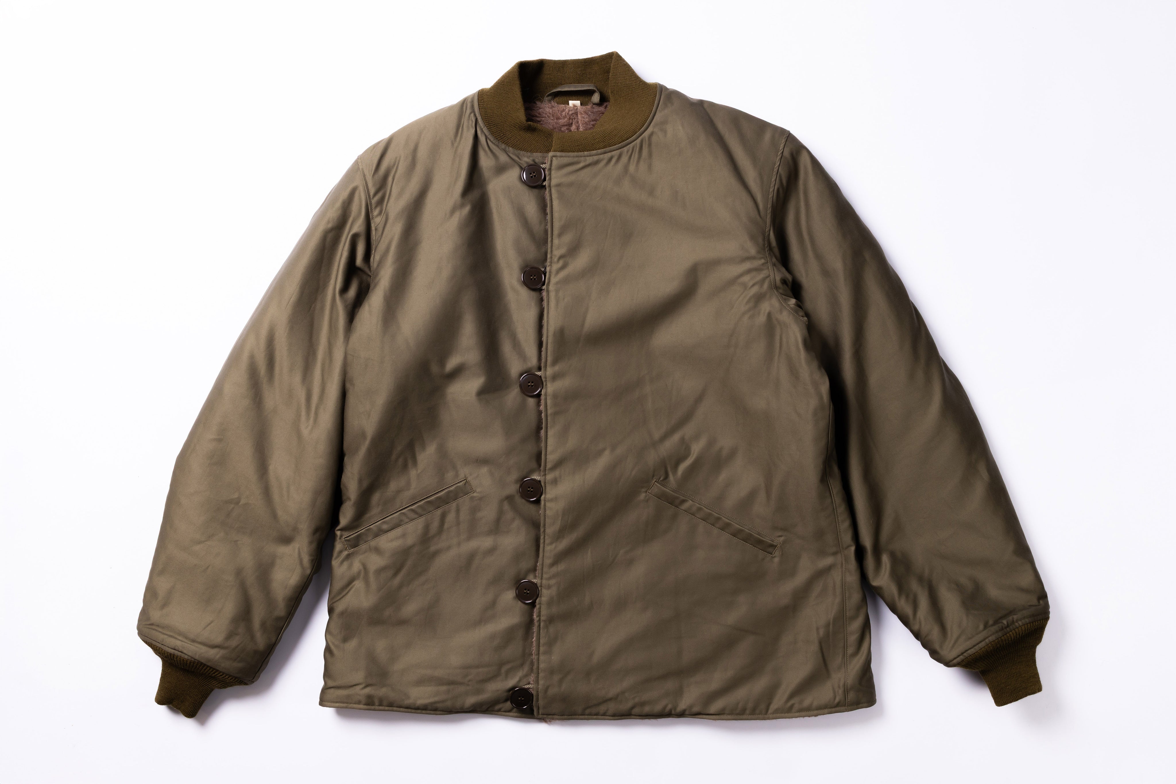 Green jacket with button details on a white background