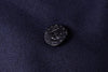 Black metal anchor pin on a dark blue fabric background