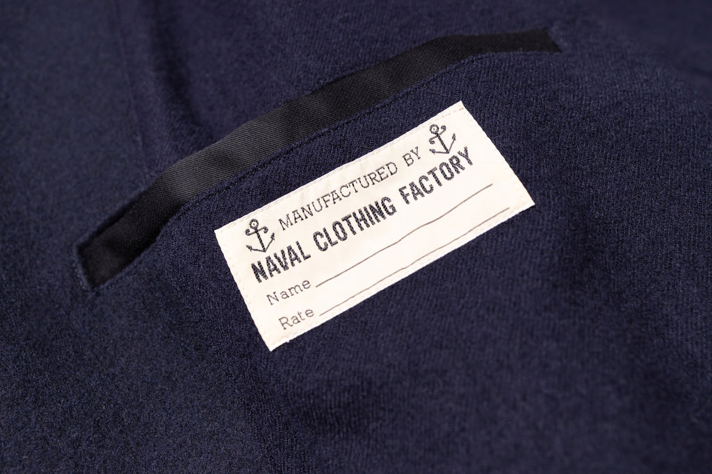 Label on a navy blue garment with 'Naval Clothing Factory' branding.
