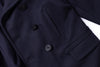 Close-up of a dark blue coat with buttons and a pocket.