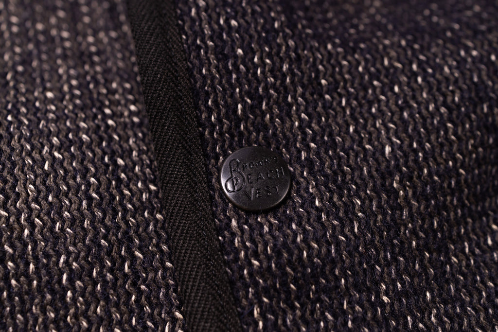 Close-up of a textured fabric with a button featuring a brand logo.