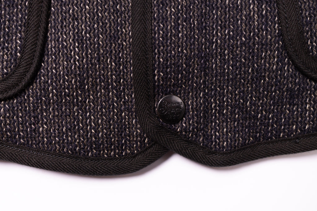 Close-up of a textured black fabric with a button on a white background