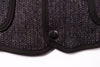 Close-up of a textured black fabric with a button on a white background