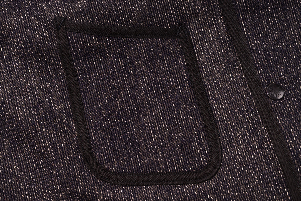 Close-up of a textured fabric pocket on a dark-colored garment.
