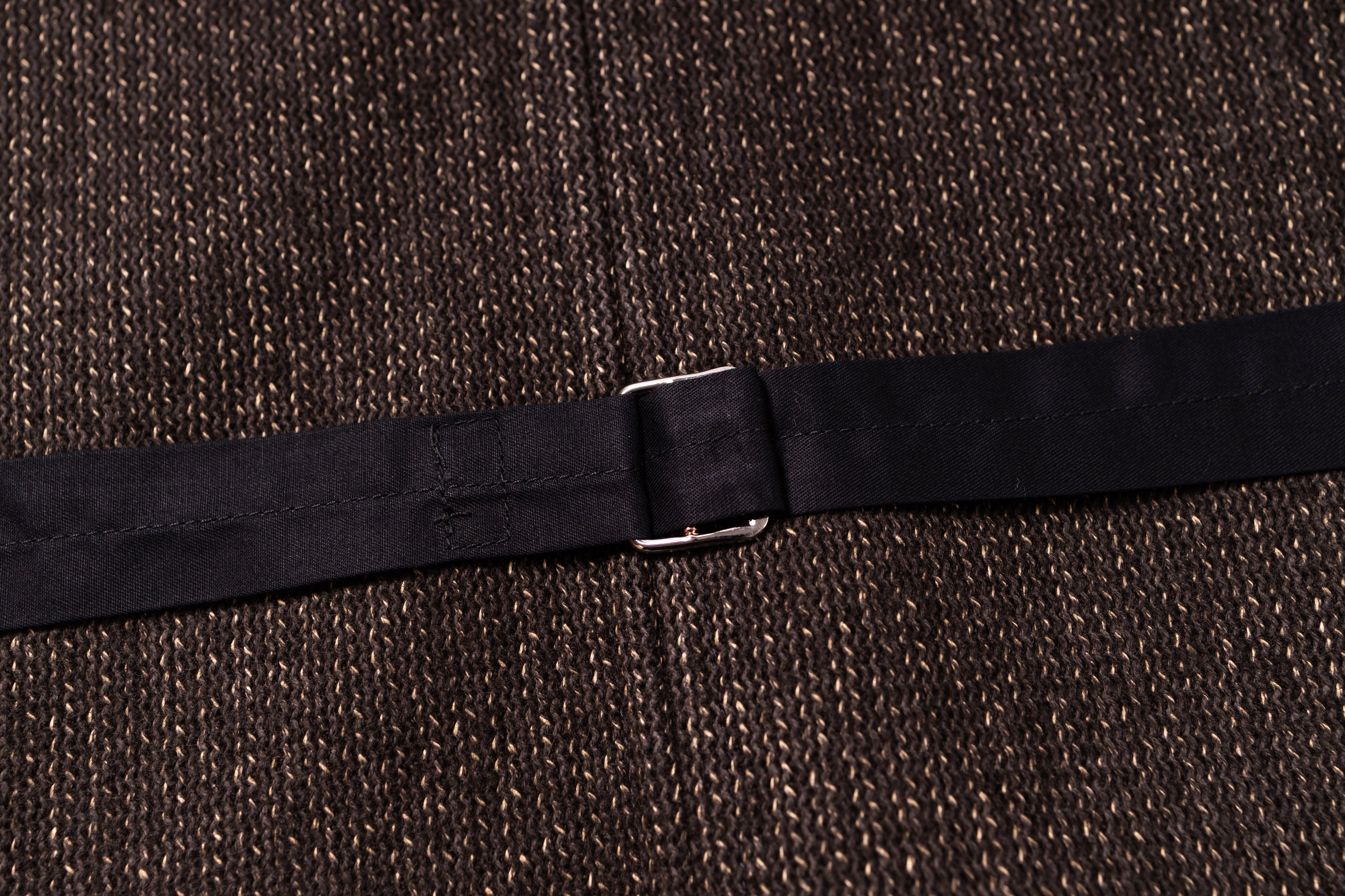 Black belt with a silver buckle on a textured brown background