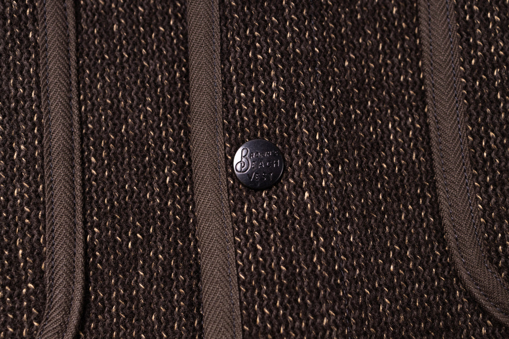 Close-up of a brown textured fabric with a brand logo in the center.