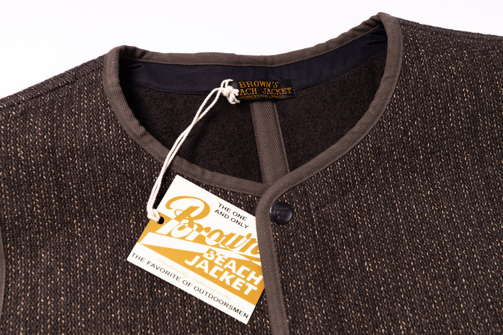 Close-up of a brown jacket with a tag on a white background