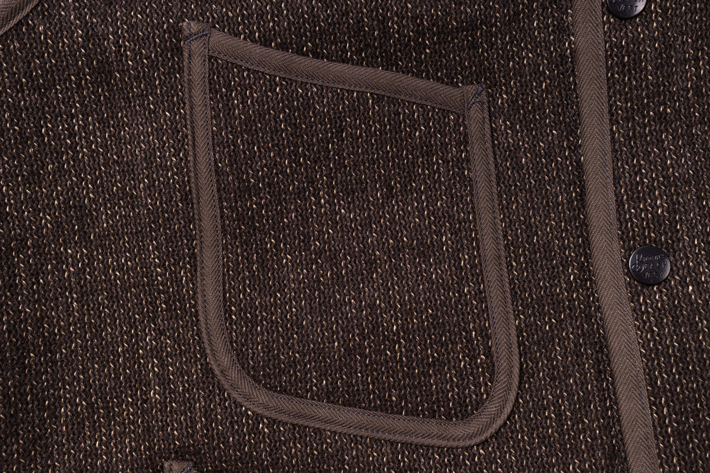 Close-up of a brown textured fabric pocket on a garment.