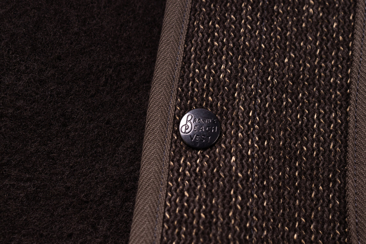Close-up of a textured brown fabric with a button featuring 'Balmorhea' branding.