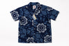 A short-sleeve button-up camp shirt in navy blue with a white floral and pinecone pattern, shown flat against a white background with retail tags attached.