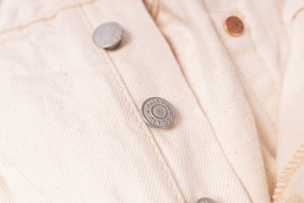 Close-up of a beige fabric with buttons on a textured background