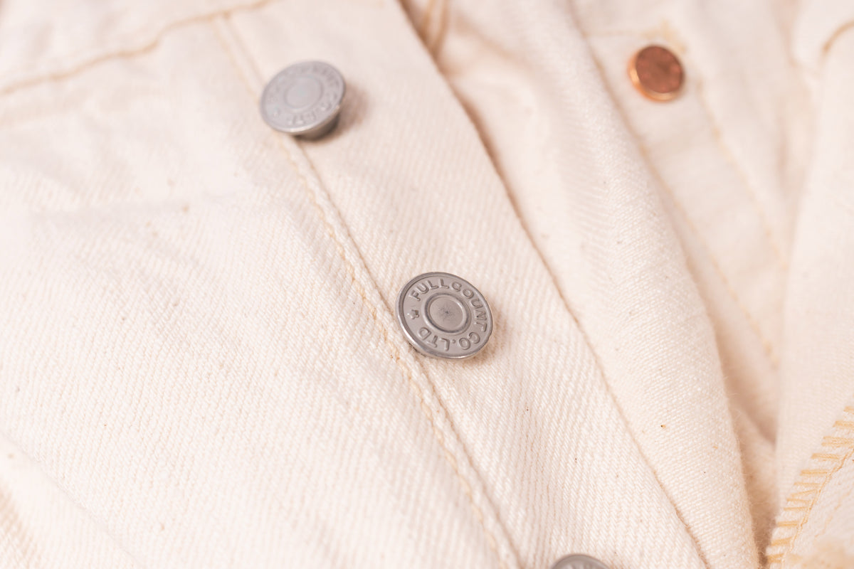 Close-up of a beige fabric with buttons on a textured background