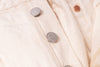 Close-up of a beige fabric with buttons on a textured background
