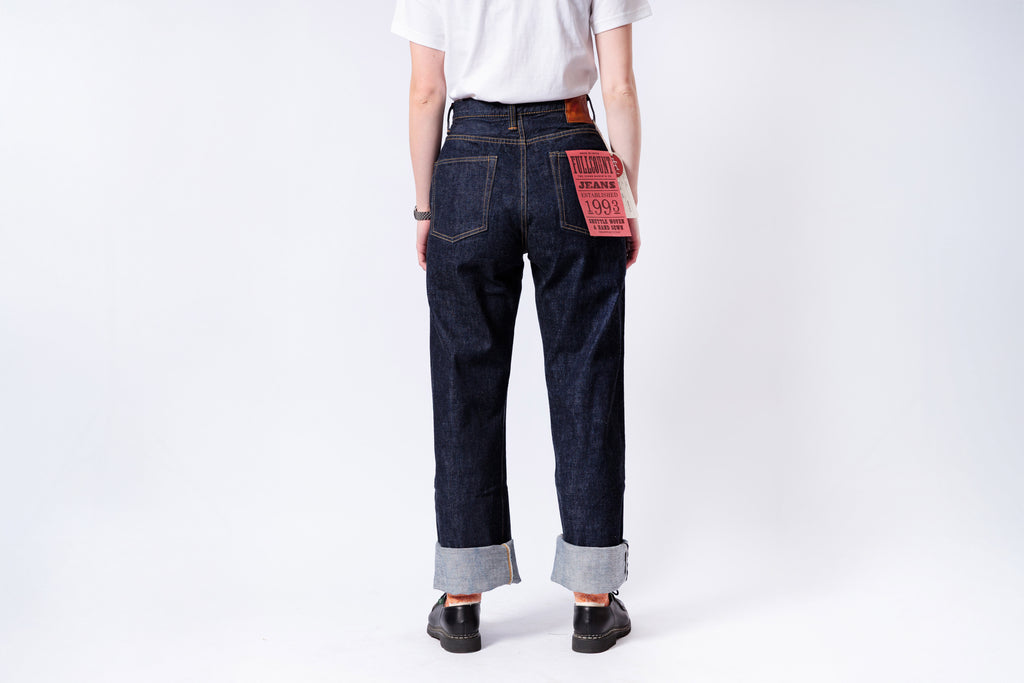 Person wearing dark blue jeans with a white background