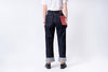 Person wearing dark blue jeans with a white background