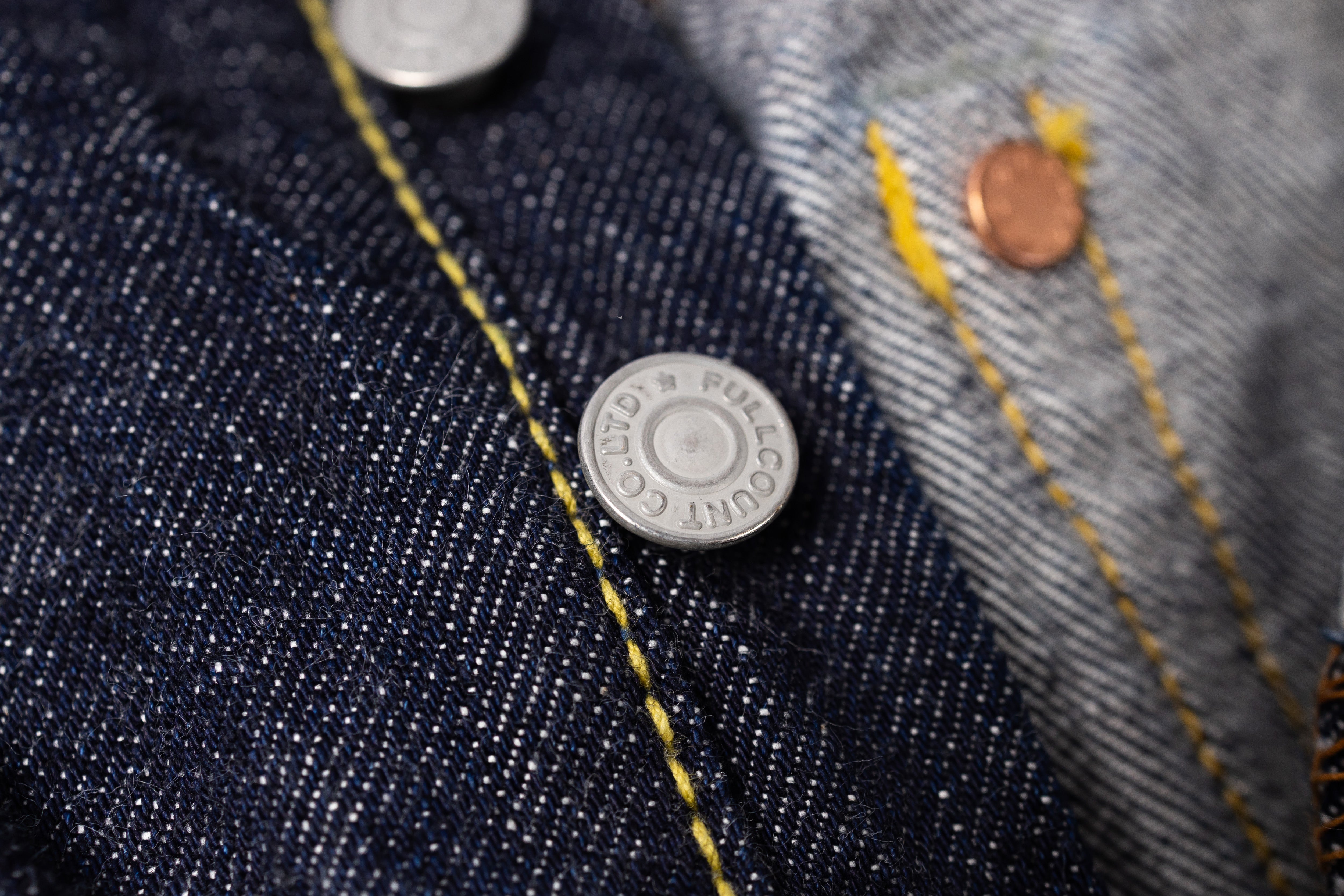 Close-up of denim fabric with buttons and stitching details