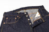 Close-up of a folded pair of dark blue jeans with a white background