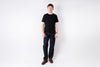 Person wearing a black t-shirt and dark pants on a white background