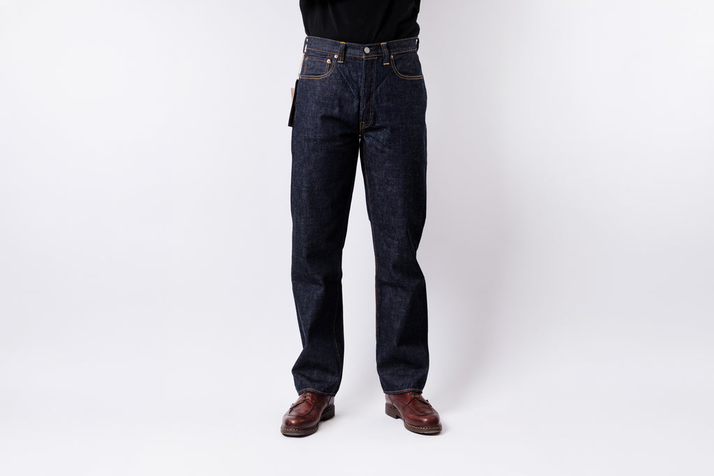 Person wearing dark blue jeans on a white background