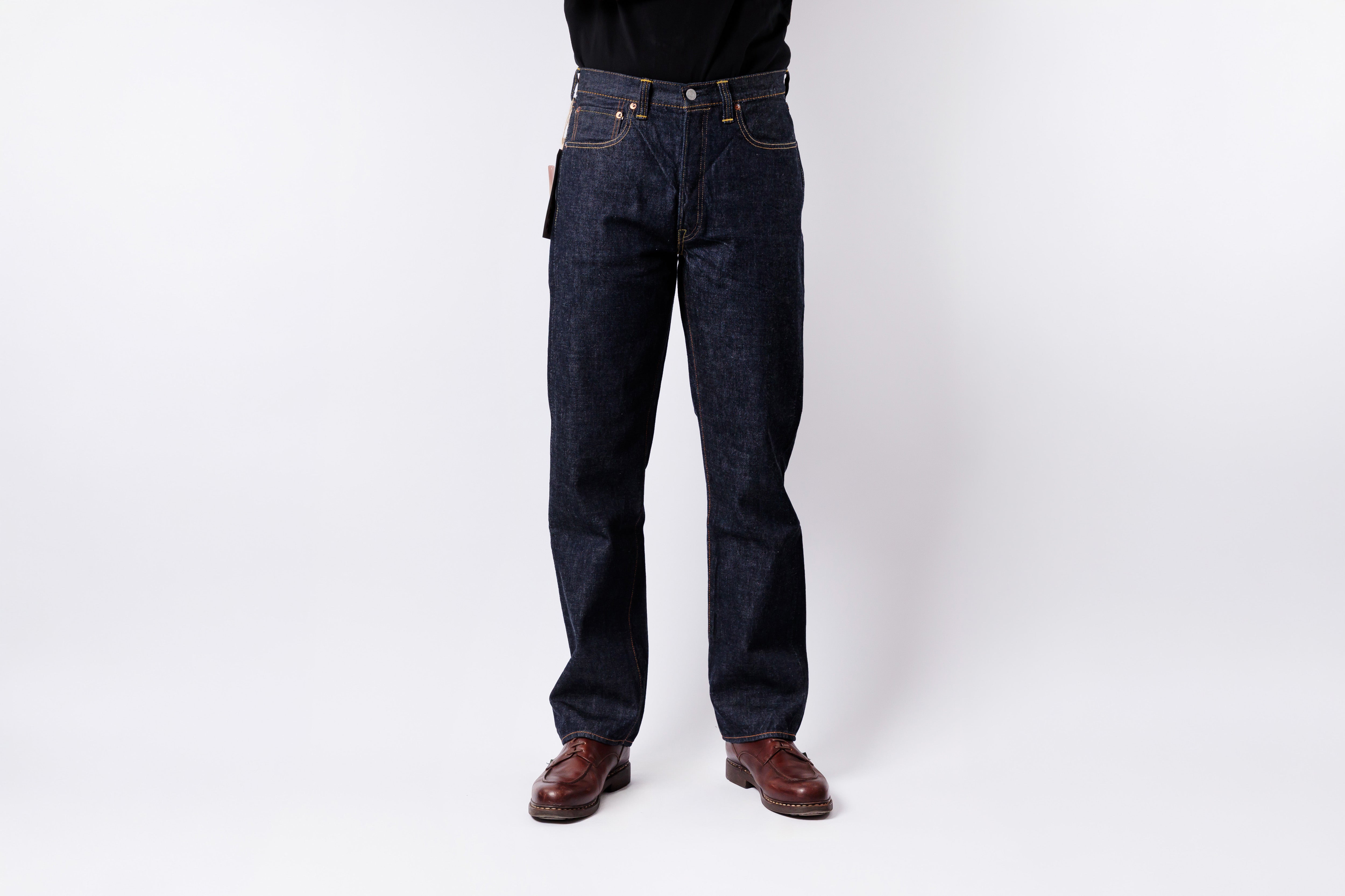 Person wearing dark blue jeans on a white background