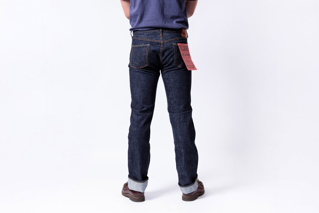 Person wearing dark blue jeans on a white background