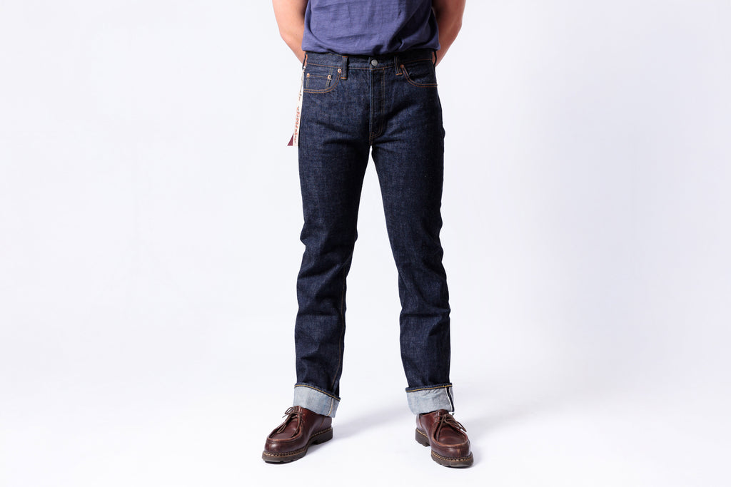 Person wearing dark blue jeans on a white background