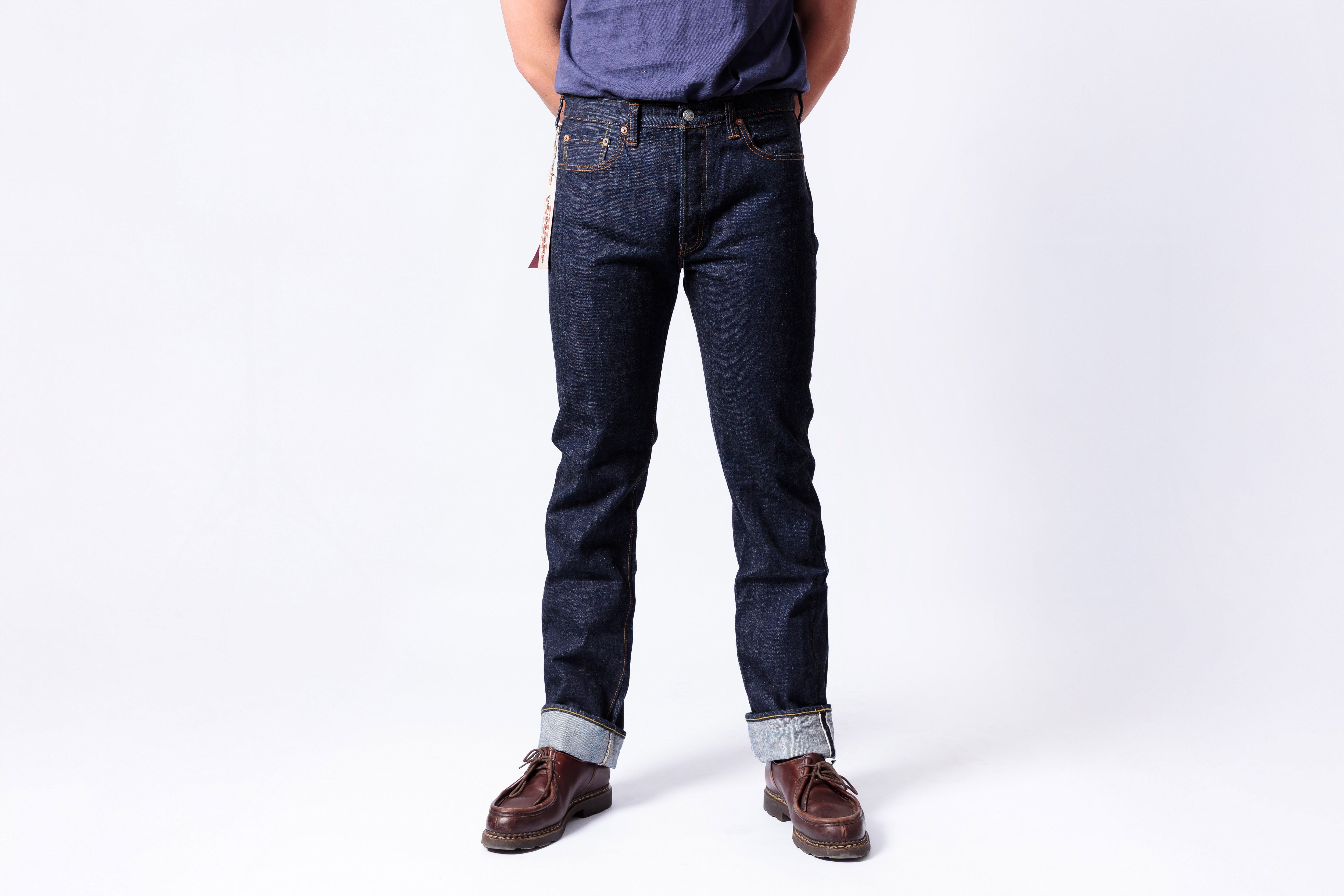 Person wearing dark blue jeans on a white background