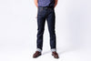 Person wearing dark blue jeans on a white background