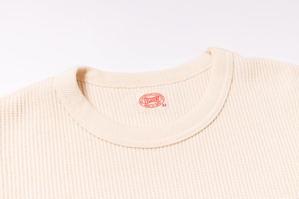 Beige sweater with a brand logo on a white background