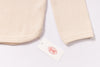 Beige textured fabric with a brand tag on a white background