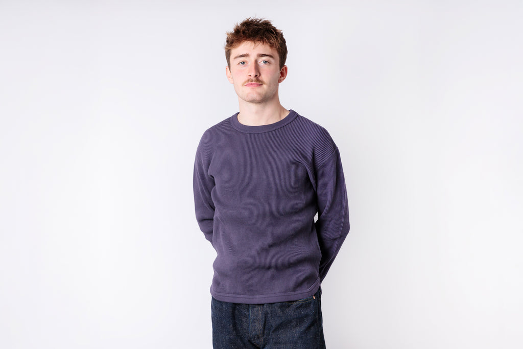 Man wearing a purple sweater against a white background