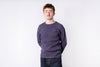 Man wearing a purple sweater against a white background