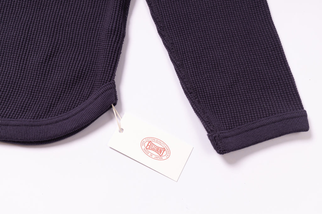 Navy textured fabric with a brand tag on a white background