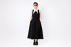 Person wearing a black dress with straps on a white background
