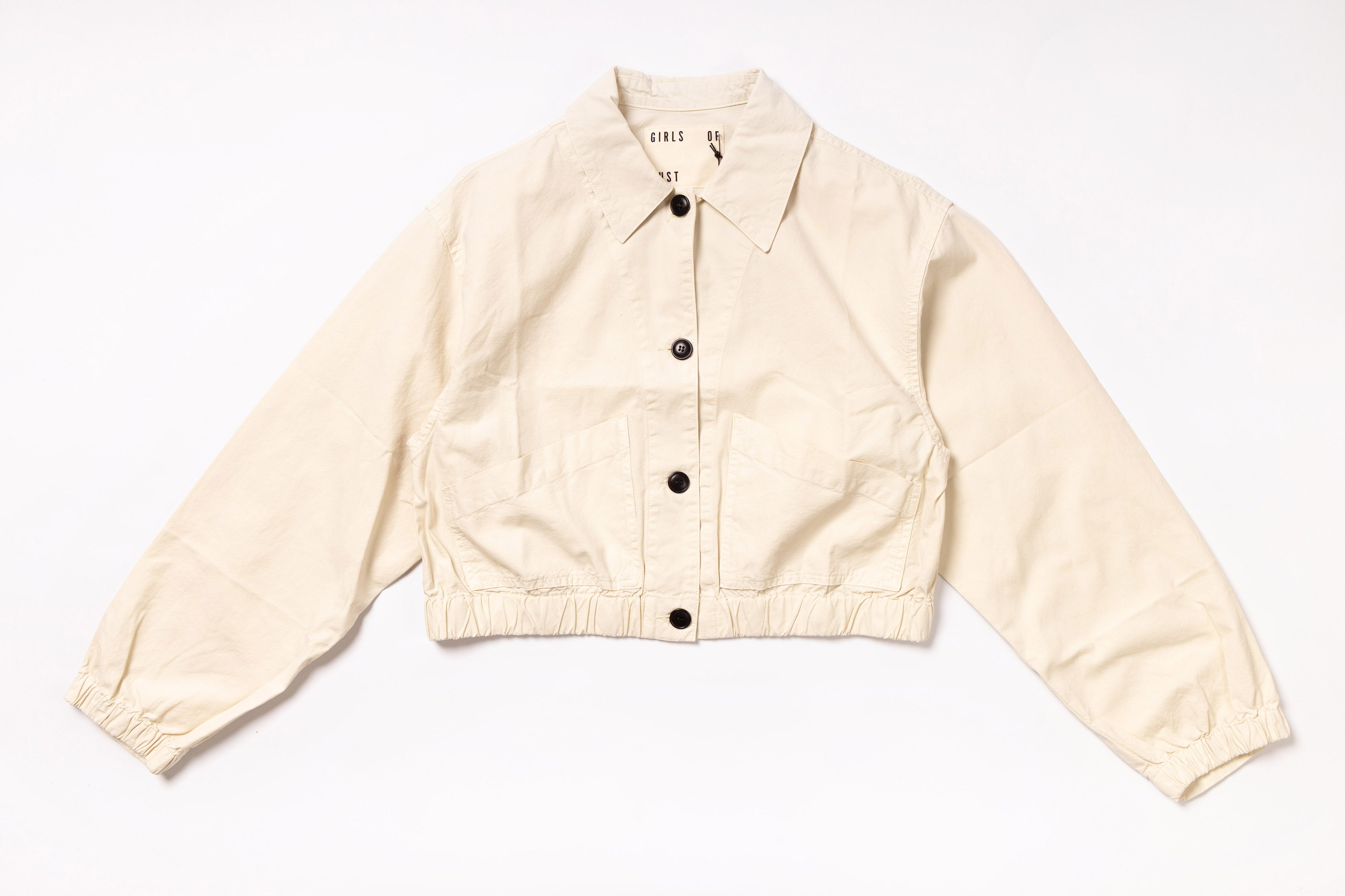 Beige jacket with black buttons on a white background