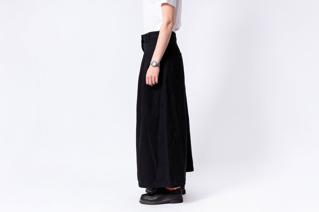 Person wearing a black wide-leg pants and white shirt on a white background