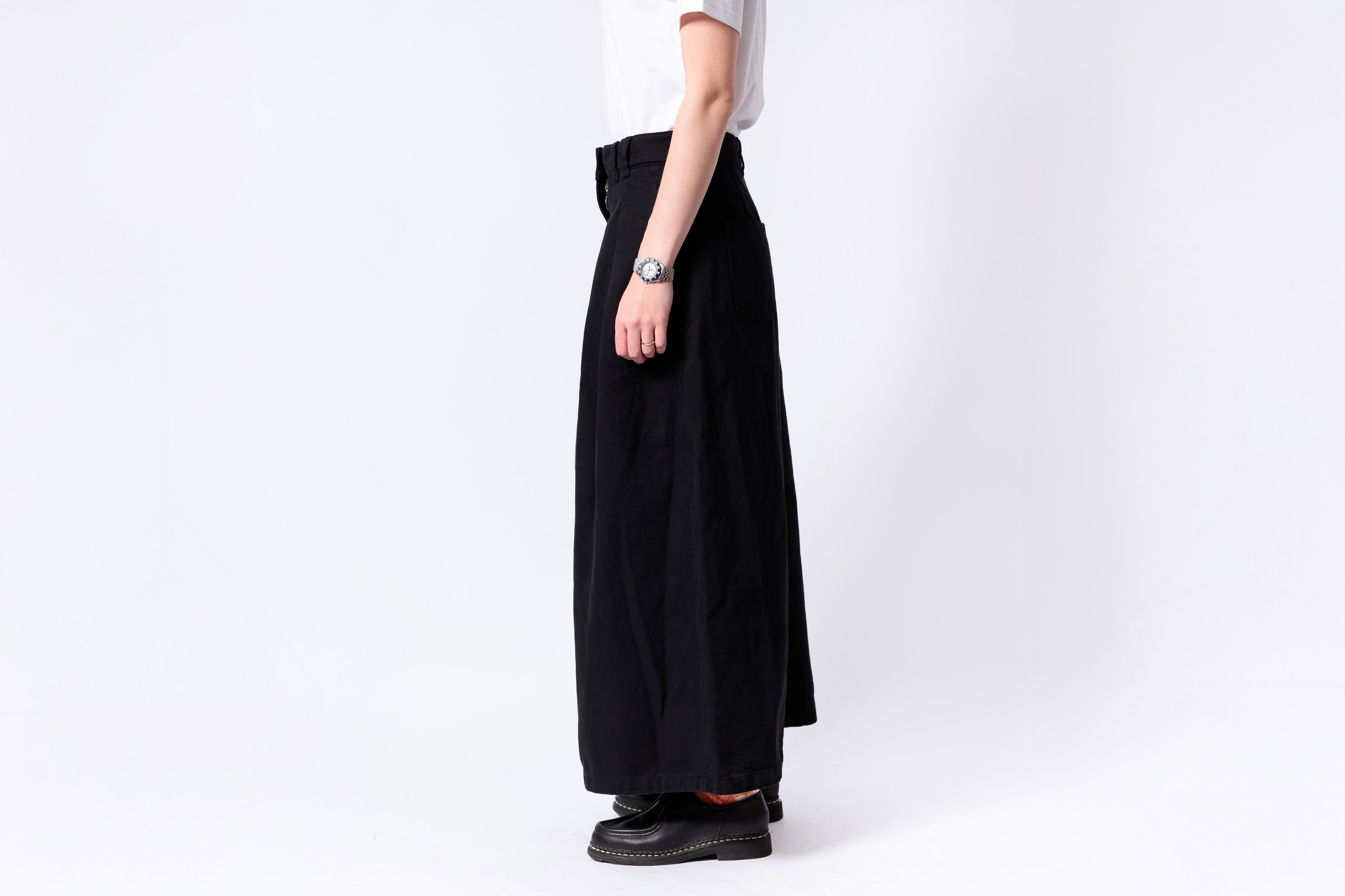 Person wearing a black wide-leg pants and white shirt on a white background