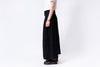 Person wearing a black wide-leg pants and white shirt on a white background