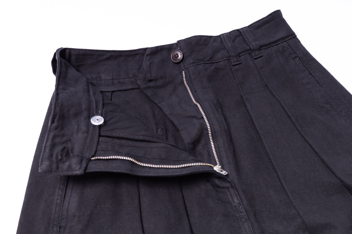 Close-up of black pants with a zipper and button on a white background